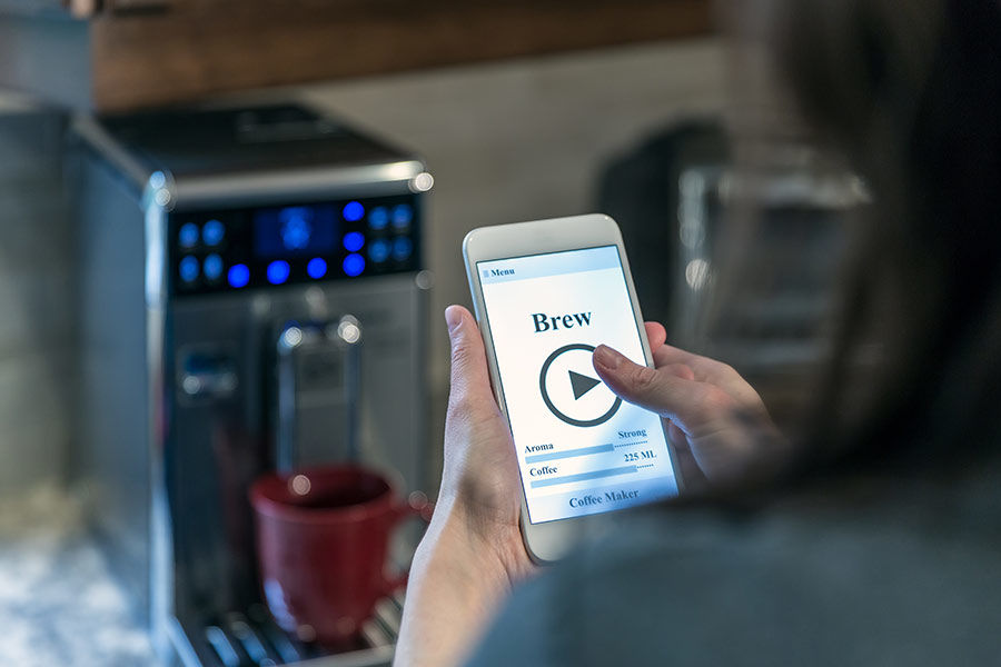 Woman brewing a cup of coffee from her phone