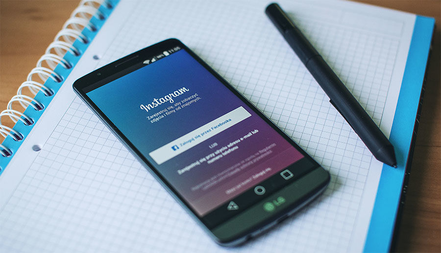 Instagram app open on smart phone thats sitting on an open notebook